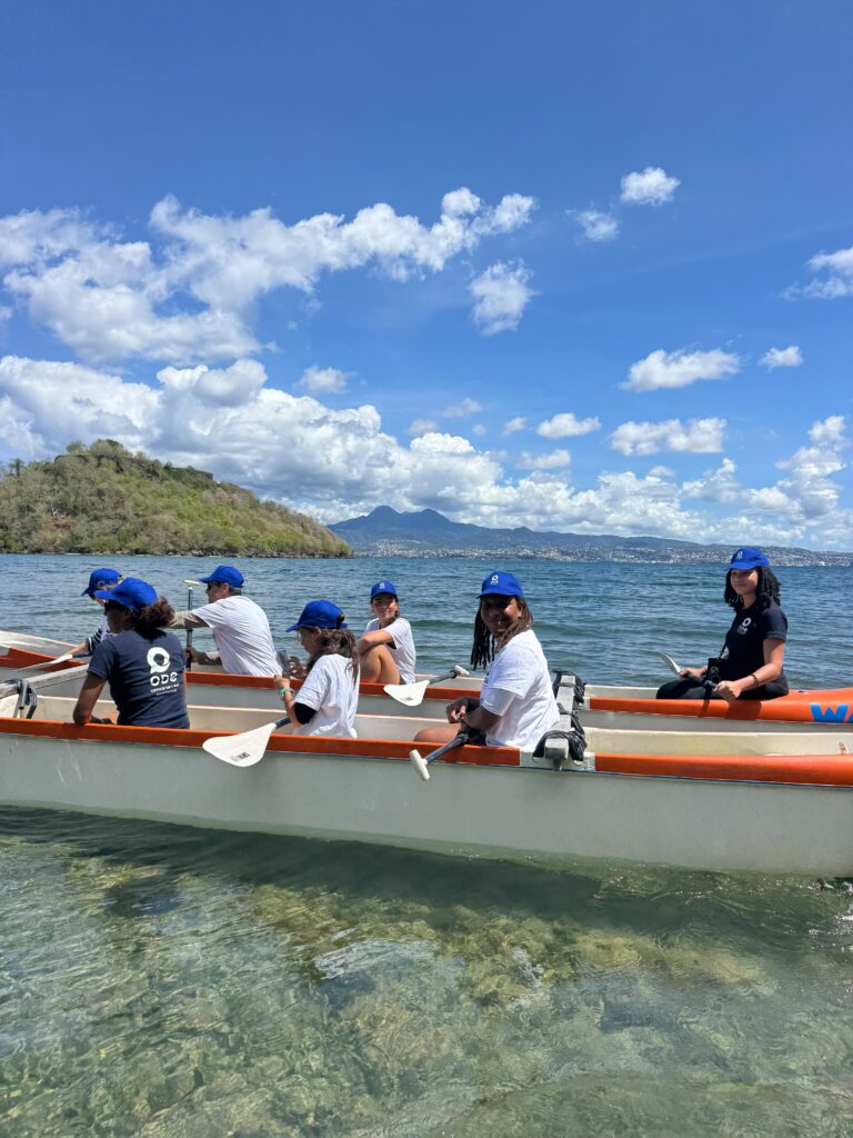 Passagers à bord de la pirogue traditionnelle de Fougè Béni naviguant sur les eaux calmes de l’Anse à l’Ane en Martinique.